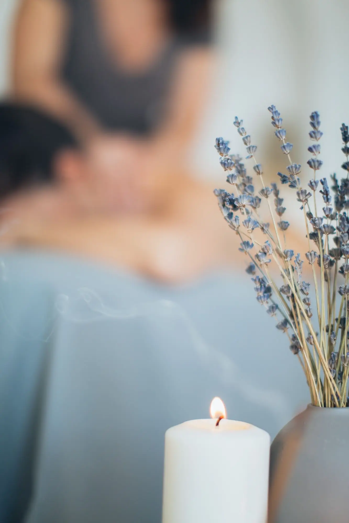 Une bougie allumée et un bouquet de lavande séchée